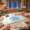 A glass cutting board featuring a blue map of Crater Lake rests on a festive kitchen counter with gingerbread cookies.