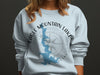 Light blue sweatshirt with Eagle Mountain Lake Texas map and compass Graphic.