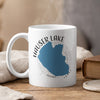 White mug with "Hauser Lake Idaho" text, blue lake outline, and compass rose graphic.