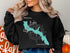 Black sweatshirt with teal map of Bass Lake, California and compass rose.