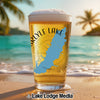 Glass of beer with Carlyle Lake outline and "Illinois" text on beach.