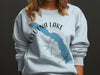 Eklutna Lake, Alaska design on a light blue crewneck sweatshirt with compass graphic.