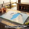 A glass cutting board rests on an outdoor wooden bar, featuring a blue outline of Lake Winnebago, Wisconsin.