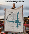 Man holding a woven blanket featuring a teal map of North Carolina, "Lake Lure" text, and a compass.