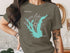 Olive green t-shirt with Calaveras Lake Texas map and compass rose graphic.