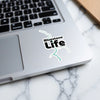 Bluestone Life sticker with teal river graphic on a laptop keyboard.