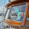"Winnipeg Life" sticker on a boat window next to "Lake Lodge Media" logo.