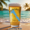 Glass of beer with blue map and compass graphic on a beach background.