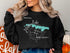 Black sweatshirt with "Beautiful Lake" and compass graphic, featuring New Jersey outline.