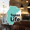 Turquoise shape sticker with black text "Topaz Life" and copyright visible.