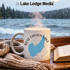 White mug with "Rose Canyon Lake Arizona" design next to a book and blanket.