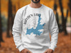 White sweatshirt with blue Hayden Lake, Idaho map and compass graphic.