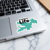 Turquoise map sticker with "Arrowhead Life" text on a laptop keyboard.