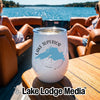 A white insulated wine tumbler with a Lake Superior graphic sits on a wooden boat table.