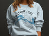 Light blue sweatshirt with Flagstaff Lake Maine design and compass rose graphic.