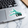 Teal Tawakoni Life sticker on a laptop keyboard.
