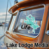Turquoise lake outline sticker and "Lake Lodge Media" text on boat window and hull.