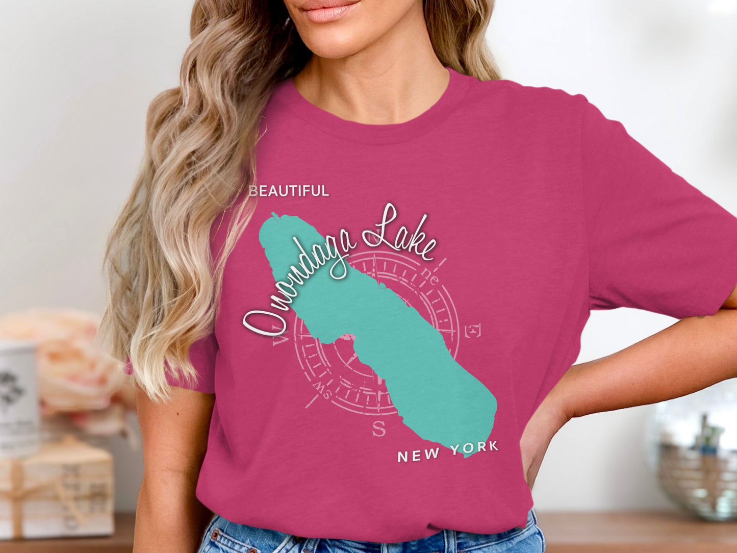 Onondaga Lake map graphic with compass rose and "New York" text on a pink t-shirt.