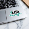 Ossawinamakee Life sticker in teal map shape on a laptop.