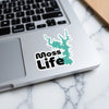 Moss Life sticker with a teal lake outline on a laptop keyboard