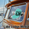 Newnans Life logo on a wooden boat with Lake Lodge Media text.