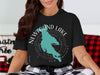 Black t-shirt with teal Newfound Lake outline, compass, and "New Hampshire" text.