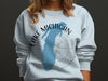Light blue sweatshirt with Lake Michigan silhouette, compass, and text.