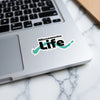 "Minnewanka Life" sticker with turquoise outline on laptop.