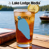 Glass of iced tea with "Lake Mohave" and compass design, lake background.