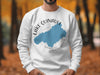 White sweatshirt with blue Lake Quinault map and compass design.