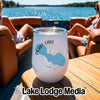 A white insulated wine tumbler with a Pearl Lake Wisconsin graphic sits on a wooden boat table.