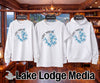 White sweatshirt, t-shirt, and hoodie with Lake Martin Alabama compass graphic.