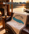 Tapestry with Donner Lake map and compass design on leather sofa, lakeside sunset.