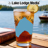 Iced tea in a glass with lemon on a table, Lake Lodge Media logo.