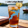 Glass of iced tea with a lemon slice and "Acadia Lake" design beside a book.