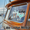 Hamilton Life logo sticker on a wooden boat window with Lake Lodge Media text.