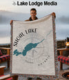 Man holding a woven throw blanket featuring a map of Shoal Lake Ontario.
