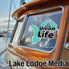 Turquoise "Union Life" sticker on a boat window, with "Lake Lodge Media" text.