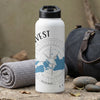 White water bottle with compass and map design, black lid, next to rolled towel.