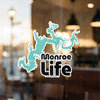 Turquoise lake shape sticker with text Monroe Life and copyright Lake Lodge Media LLC.
