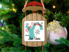 Sled ornament with "Merry Christmas FROM Lake Union" inscription hangs on a decorated Christmas tree.