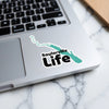 Sailorville Life sticker with teal outline and black text on a laptop