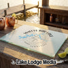 Textured glass cutting board printed with a Watts Bar Lake map design rests on a wooden table.