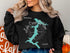 Black sweatshirt with "Lake Coeur d'Alene Idaho" and compass graphic.