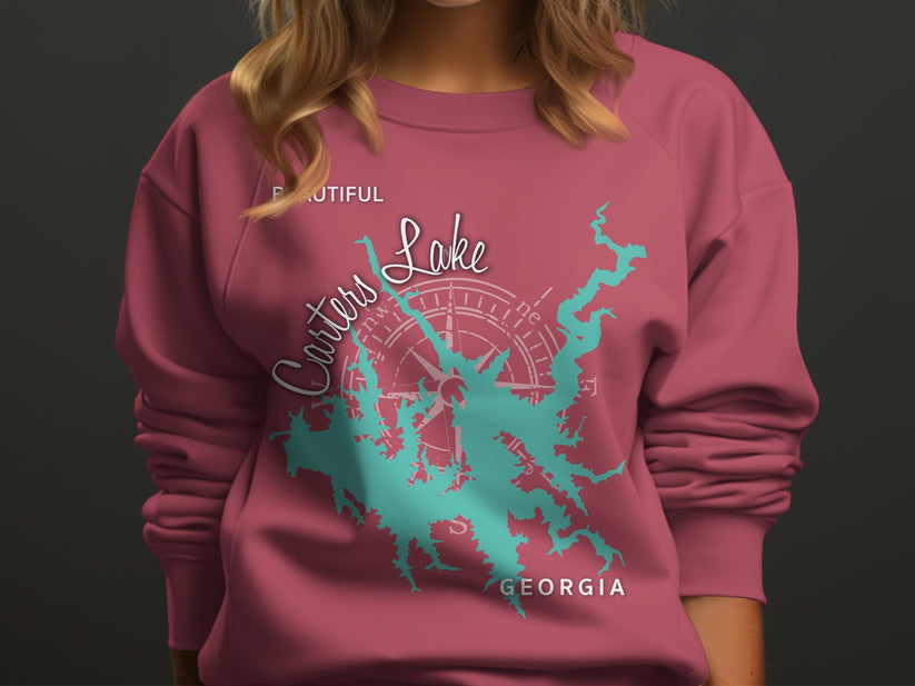 Pink sweatshirt with teal Carters Lake map and compass graphic.