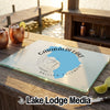A glass cutting board featuring a blue map of Garibaldi Lake sits on a wooden dock.