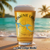 Glass of beer with "Lamonie Lake" and map design on a beach.