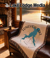 Woven blanket featuring Longview Lake shape and compass rose on a leather couch.