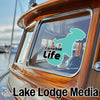 Turquoise Canobie Life sticker on a boat window with "Lake Lodge Media" logo.