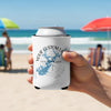 White can cooler with custom lake and compass design held by hand on beach